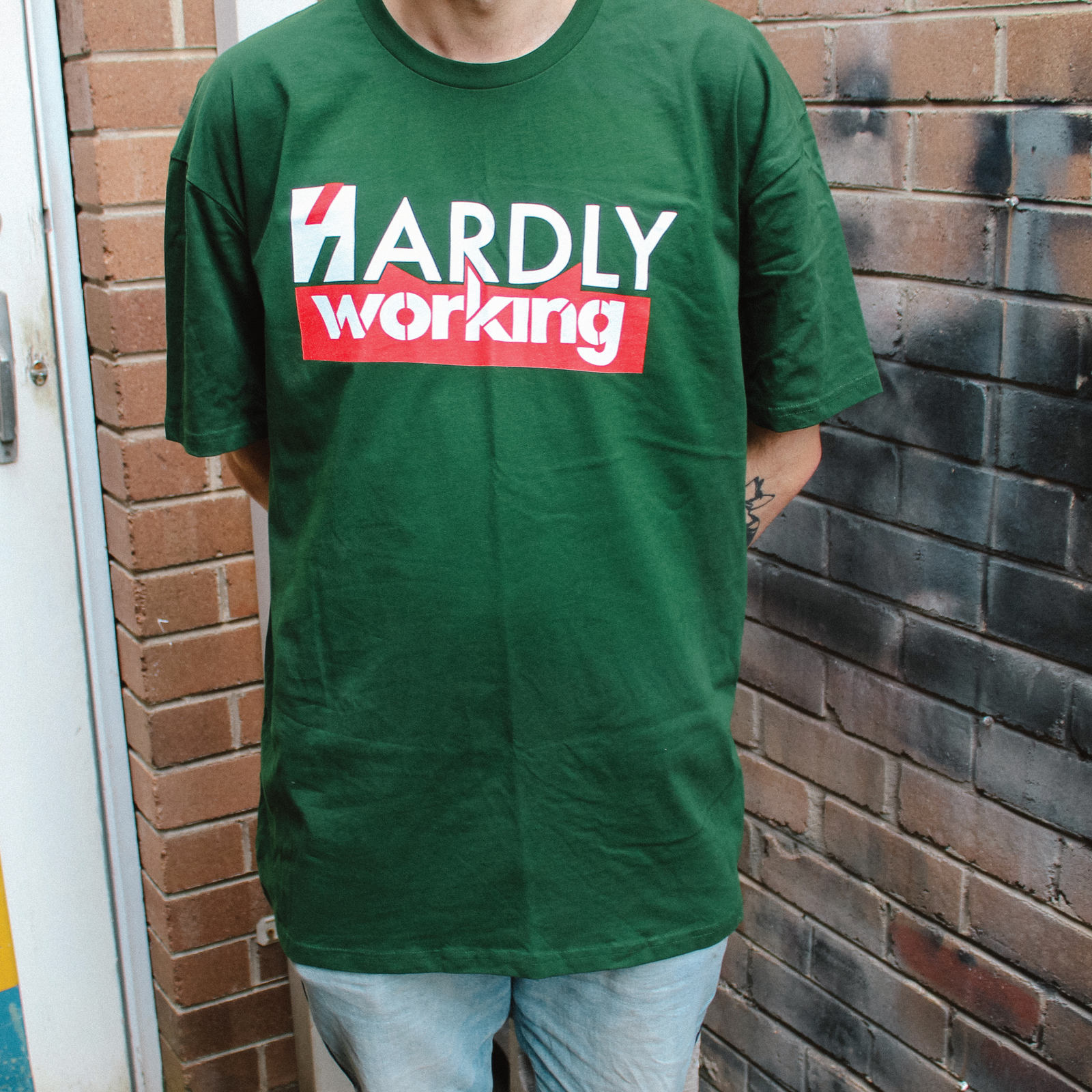 Forest Green unisex t-shirt with Hardly Working graphic by Lonely Kids Club